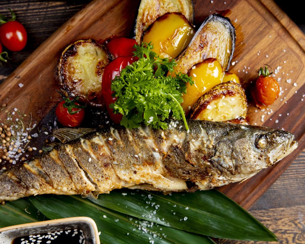 fried fish with grilled eggplants bell peppers and tomatoes