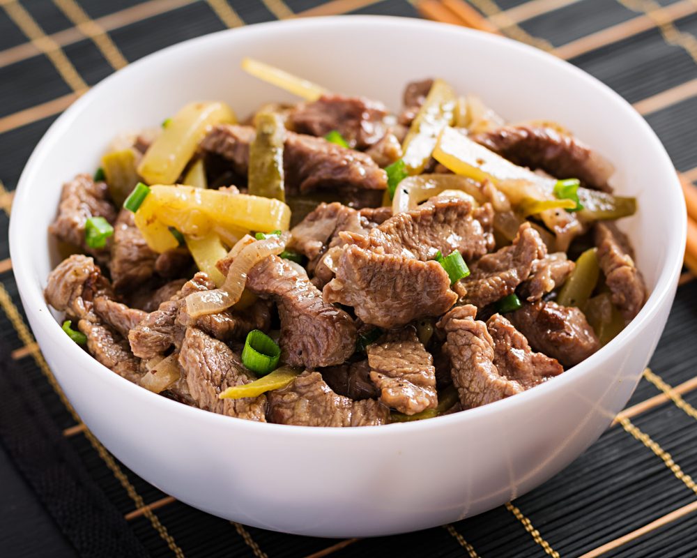 Stew beef, pieces of beef stewed in soy sauce with spices with pickled cucumber in asian style.